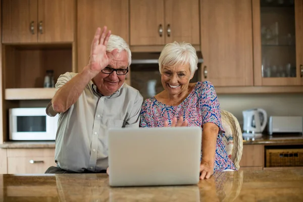 Äldre par med laptop i köket — Stockfoto