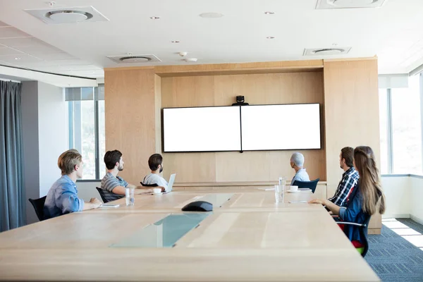 Tim bisnis kreatif yang menghadiri panggilan video di ruang konferensi — Stok Foto