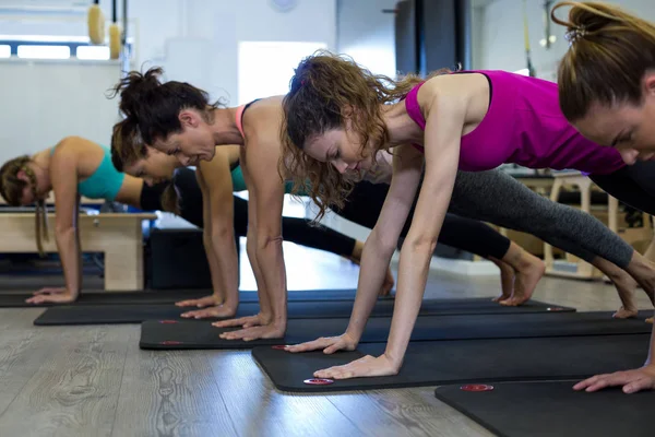Women performing stretching exercise on exercise mat — Stock Photo, Image
