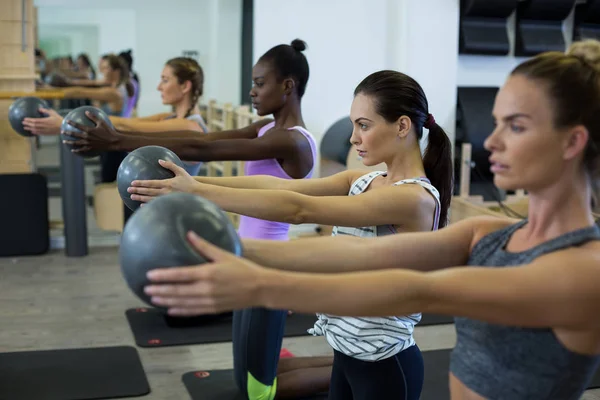 适合在健身房中执行健身球伸展运动的妇女 — 图库照片