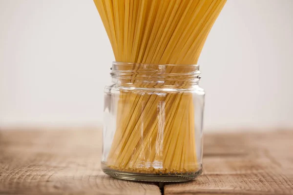 Paquete de espaguetis crudos en frasco de vidrio — Foto de Stock