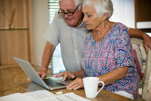 Senior kvinna använder laptop i köket — Stockfoto