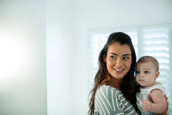 Mãe segurando sua menina e olhando para o espelho — Fotografia de Stock