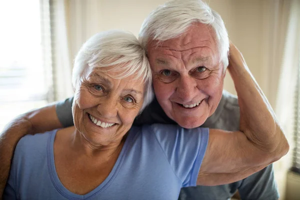 Porträt eines älteren Paares, das sich im Schlafzimmer umarmt — Stockfoto