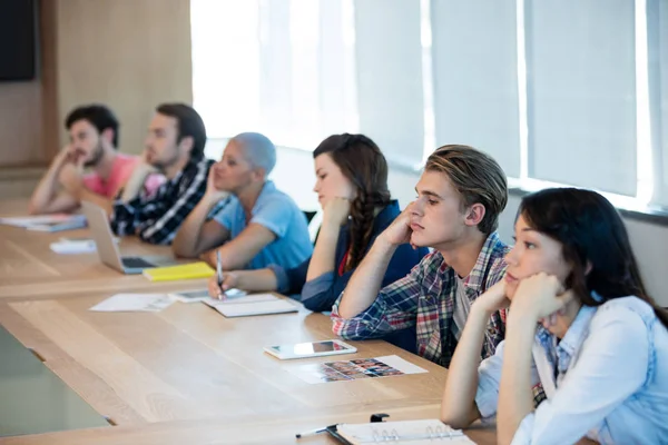 Uttråkad creative business-team som deltar i ett möte — Stockfoto