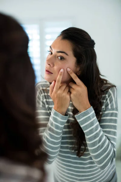 Femme appuyant sur les boutons devant le miroir de salle de bain — Photo