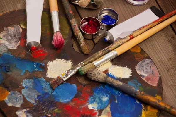 Palet met meerdere kleuren, aquarel en verf penselen — Stockfoto