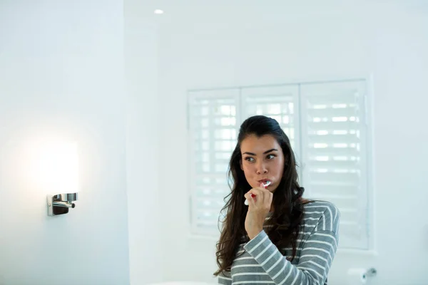 Mulher escovando os dentes no banheiro — Fotografia de Stock