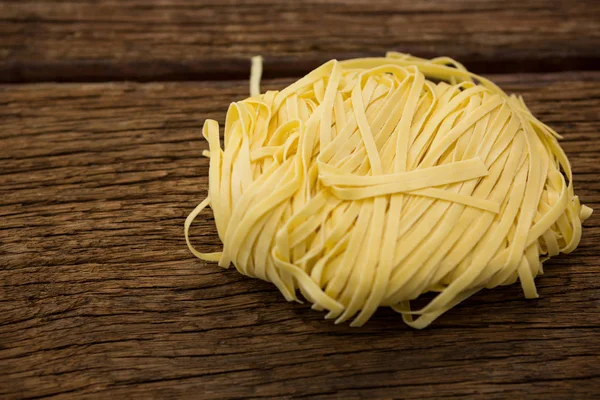 Pasta Tagliatelle sobre superficie de madera —  Fotos de Stock