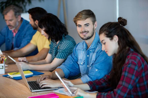 Glimlachende man aan het werk met zijn team van creatieve business — Stockfoto