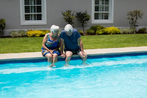 Coppia anziana che interagisce tra loro a bordo piscina — Foto Stock