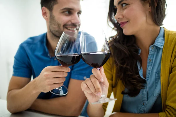 Casal brindar copos de vinho tinto na cozinha — Fotografia de Stock