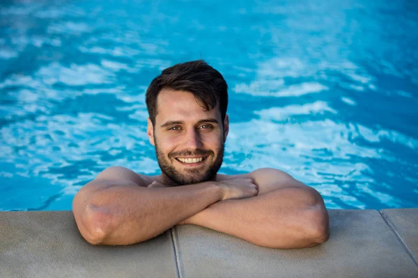 Portret van jonge man ontspannen in het zwembad — Stockfoto