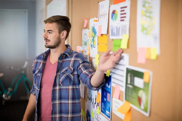 Homme pointant vers des notes collantes sur le tableau — Photo