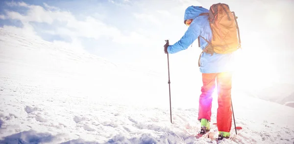 Лижник, що йде на схилі з лижами — стокове фото