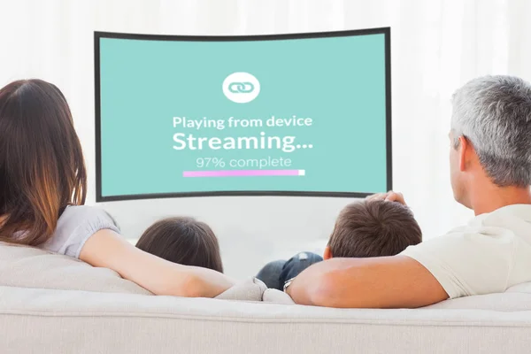Familjen sitter på soffan tittar på TV tillsammans — Stockfoto
