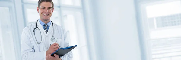 Smiling doctor writing on clipboard — Stock Photo, Image