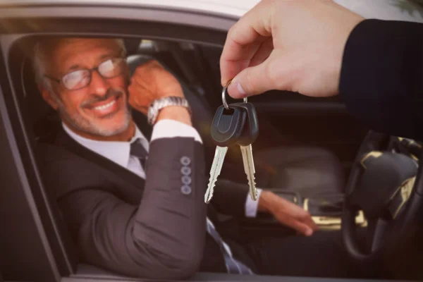 Imagem composta de mulher sorrindo ao receber chaves do carro — Fotografia de Stock