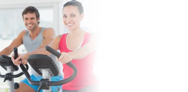 Pareja haciendo ejercicio en la clase de spinning —  Fotos de Stock