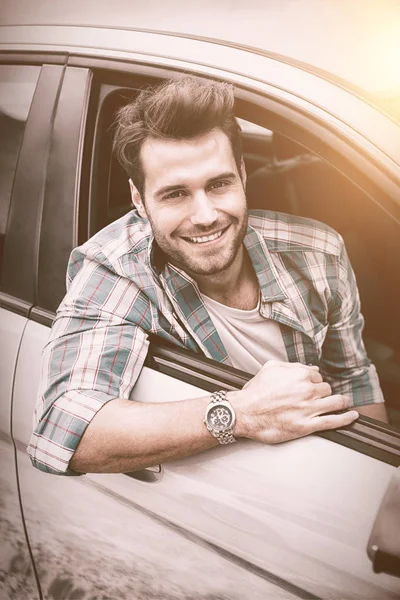 Улыбающийся мужчина сидит в своей машине — стоковое фото