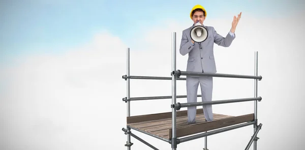 Man in helmet standing on scaffolding — Stock Photo, Image