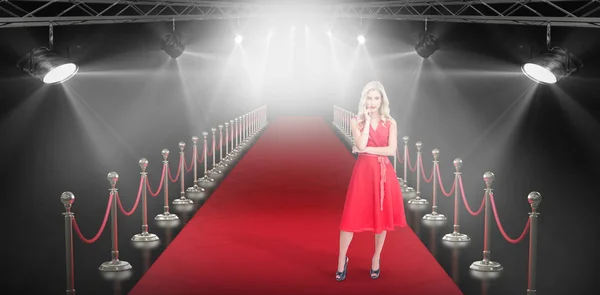 Composite image of thoughtful blonde wearing red dress — Stock Photo, Image