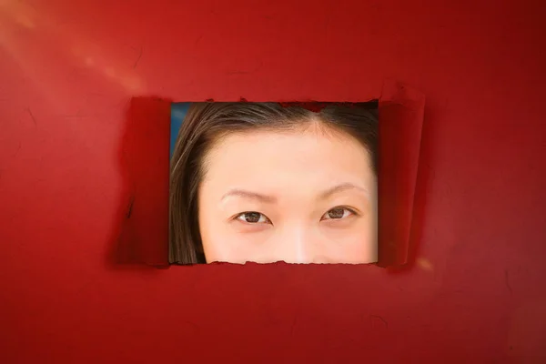 Woman looking out of hole — Stock Photo, Image