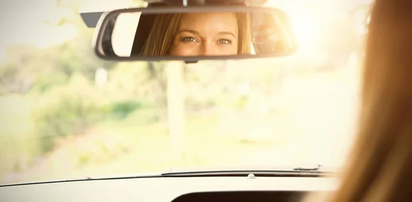 Mulher olhando para o espelho no carro — Fotografia de Stock