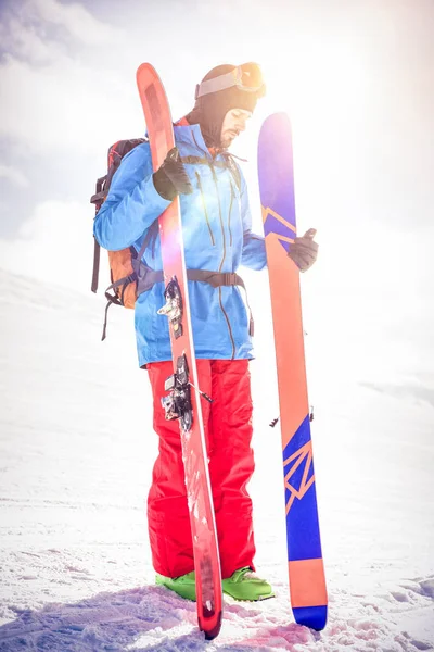 Skier тримає лижі на засніжених горах — стокове фото