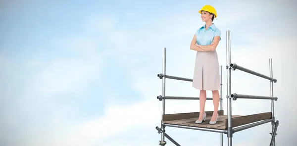 Mulher de capacete em pé sobre andaimes — Fotografia de Stock