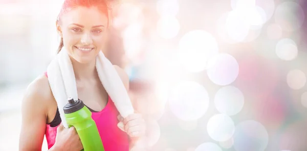 Smiling woman with towel and bottle — Stock Photo, Image