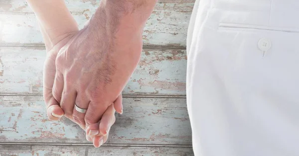 Hochzeitspaar hält Händchen gegen Holz — Stockfoto