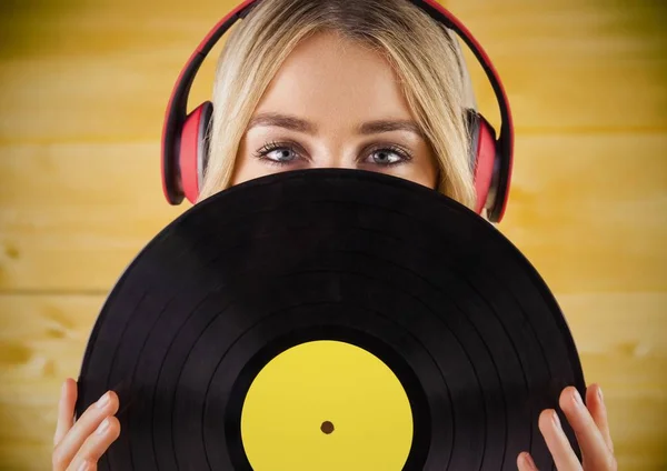 Mujer con auriculares y registro contra panel de madera amarilla —  Fotos de Stock