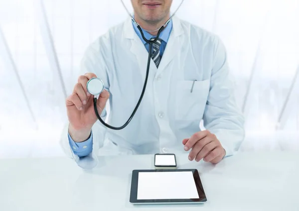 Médico com estetoscópio e dispositivos na mesa contra janela embaçada — Fotografia de Stock