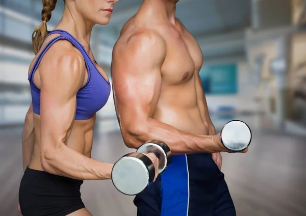 Homme et femme mi-sections haltérophilie dans la salle de gym floue — Photo