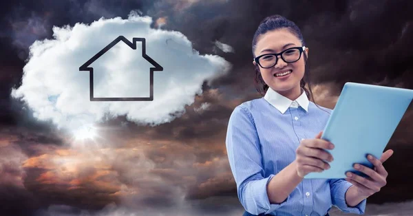 Mujer con tableta y nube con casa contra cielo tormentoso —  Fotos de Stock