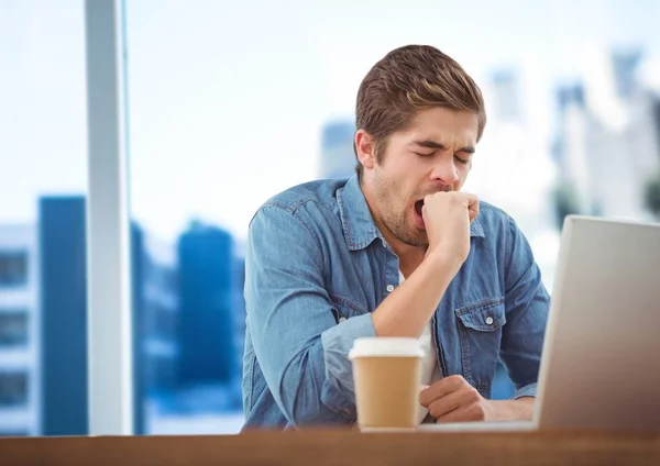 Man med laptop och kaffe mot suddiga blå skyline — Stockfoto