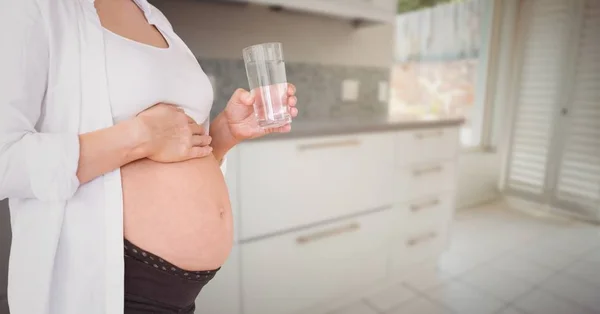 Femme enceinte milieu de section avec verre d'eau — Photo