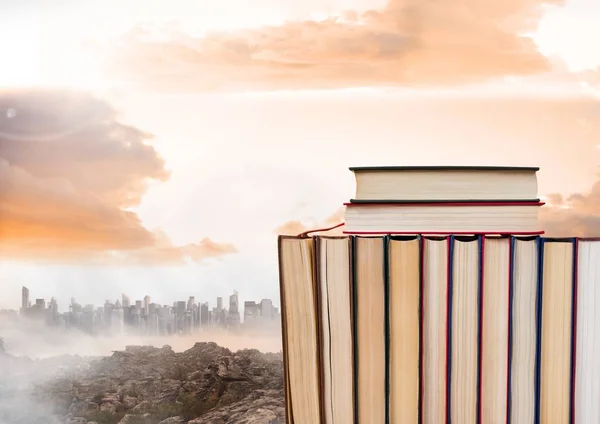 Boeken gestapeld door verre stad en wolken — Stockfoto
