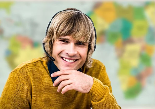 Travel agent in headset against blurry map — Stock Photo, Image