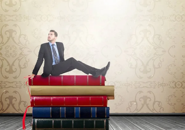 Man zit op boeken gestapeld door rustieke behang — Stockfoto