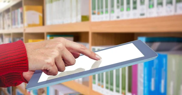 Hand op tablet in bibliotheek — Stockfoto