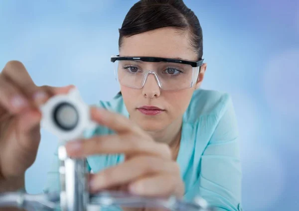 Close up of woman with electronics against blurry blue background — Stock Photo, Image