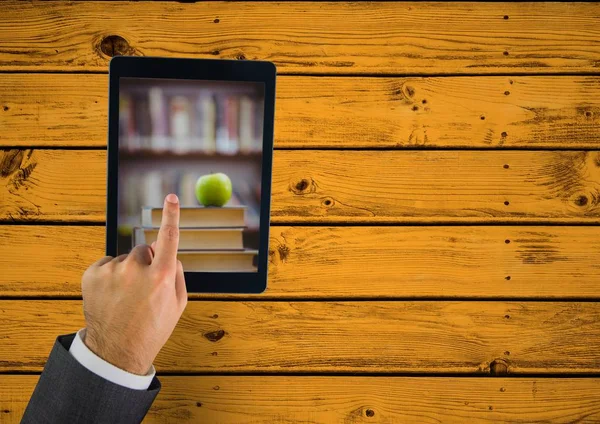 Tablet zum Anfassen zeigt Bücherstapel mit Apfel auf gelbem Tisch — Stockfoto