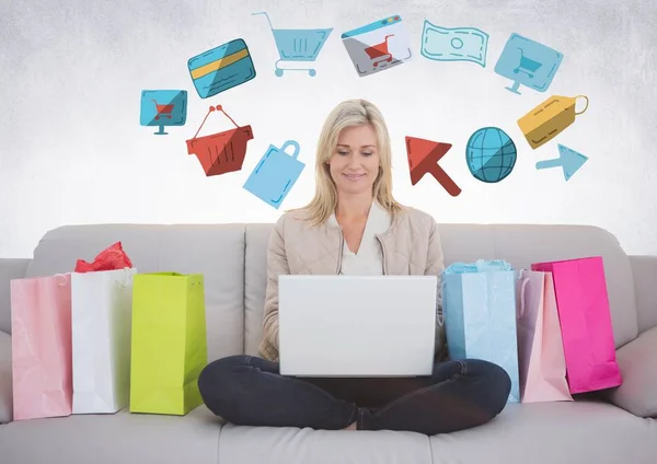 Mujer en el sofá con bolsas de compras y dibujos gráficos de compras en línea —  Fotos de Stock