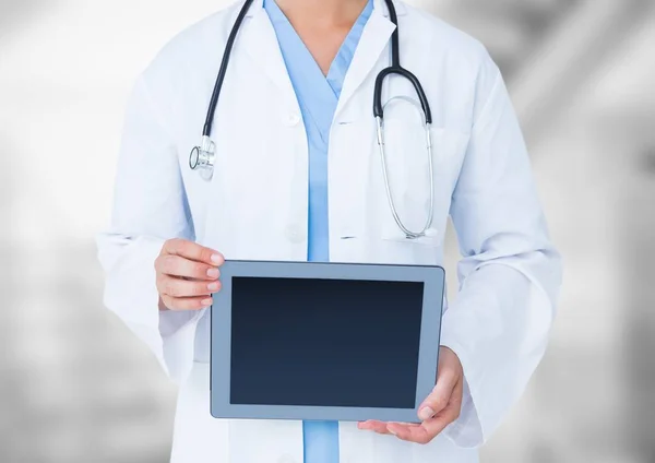 Médico de sección media con tableta contra fondo borroso — Foto de Stock