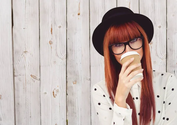 Mujer en camisa de lunares con taza de café sobre la cara contra el panel de madera blanca — Foto de Stock