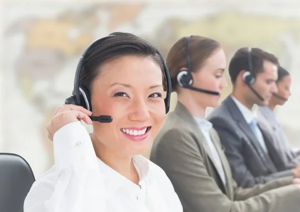 Travel agents with headsets against blurry map — Stock Photo, Image