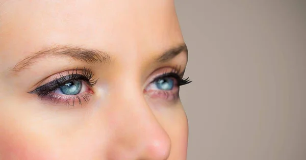 Närbild på kvinnans ögon mot brun bakgrund — Stockfoto