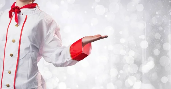 Chef with hand out at side against white bokeh — Stock Photo, Image